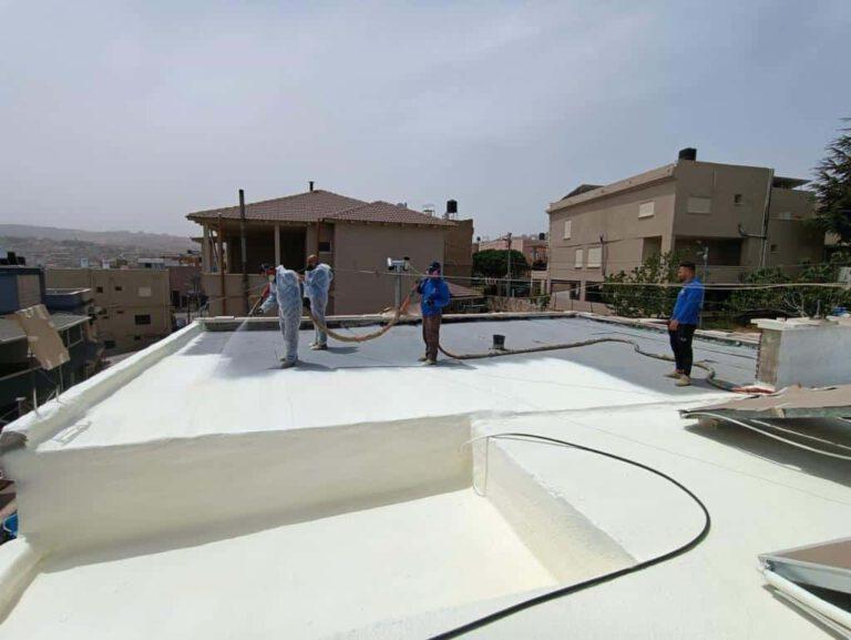 איטום גגות בבאר שבע — איטום הגג נגד נזילות בדרום – בסיס עבודות בגובה עובדים מבצעים איטום גג עם חומר מיוחד על גג בניין.