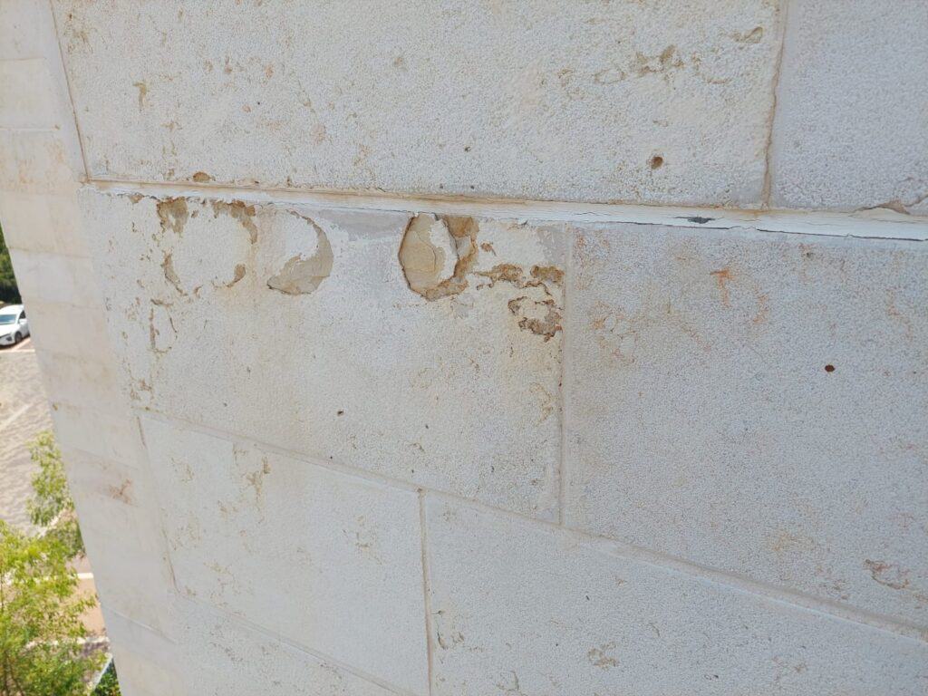כמה עולה הסרת צו מבנה מסוכן? פירוק עלויות מלא – בסיס עבודות בגובה התקלפות חיפוי אבן בחזית בניין — ליקוי אופייני בדוח מהנדס לצו מבנה מסוכן