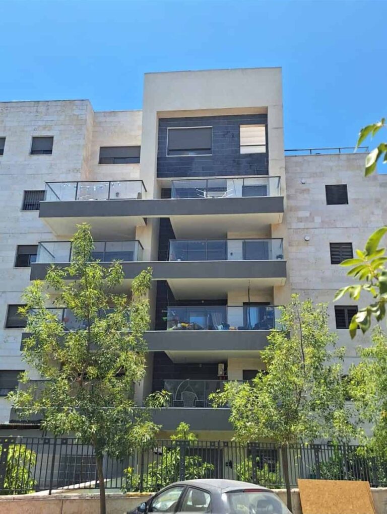 מאמרים עבודות בגובה – בסיס עבודות בגובה חזית בניין מגורים מודרני עם מרפסות מעקה זכוכית ועצים ירוקים בחזיתו
