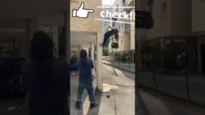 עובד בגובה על סולם, מבצע בדיקת בטיחות באתר בנייה.