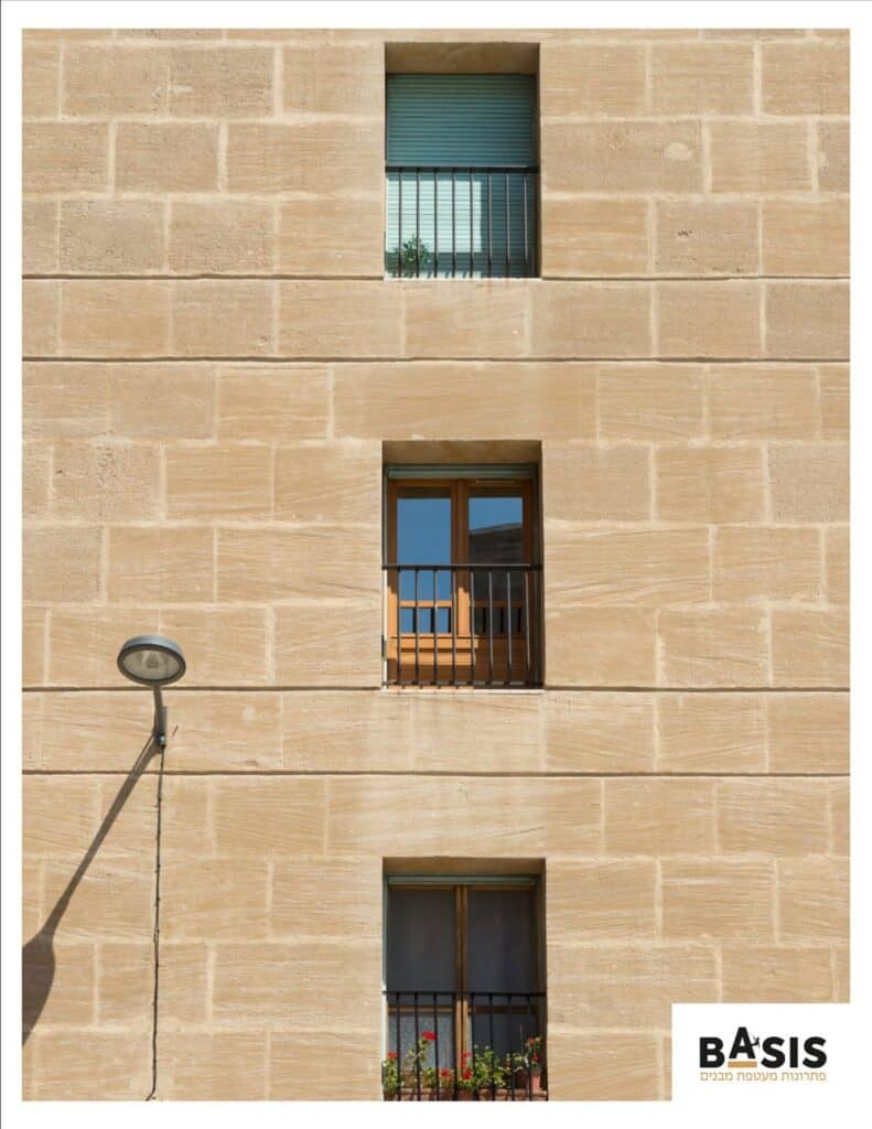 עבודות בגובה על בניין עם חלונות ותריסים.
