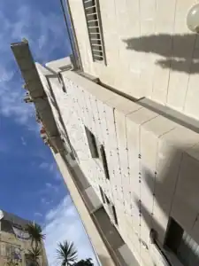 עבודות בגובה על בניין גבוה עם ציוד בטיחות מקצועי.