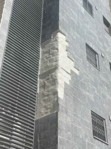 עבודות בגובה על קיר בניין עם סולם ומעקות בטיחות.