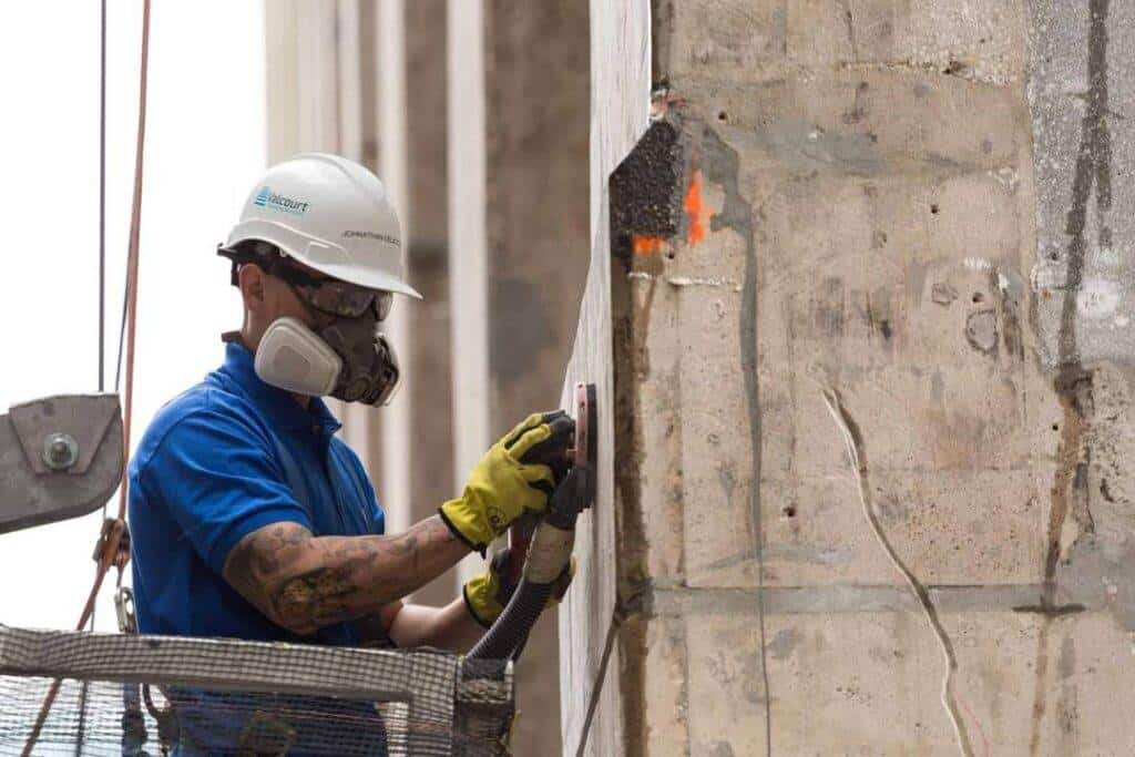 קבלן בגובה עם ציוד בטיחות מבצע עבודות בניין בגובה.