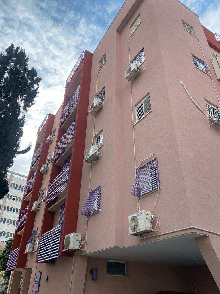עבודות בגובה על בניין מגורים עם מערכות מיזוג אוויר ומרפסות.