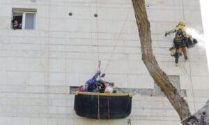 עובדי גובה מבצעים עבודות בניין עם ציוד בטיחות.